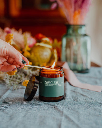 woodland candle being lit with hand and matchstick